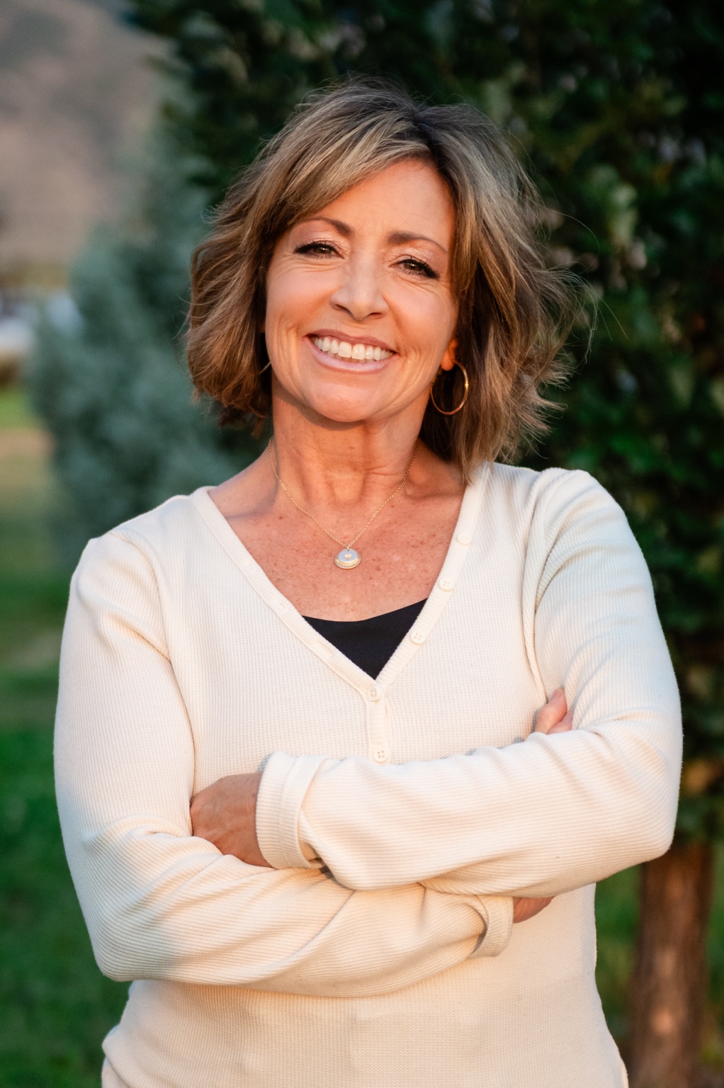 Laurrie Livermore smiling outdoors in a cream sweater